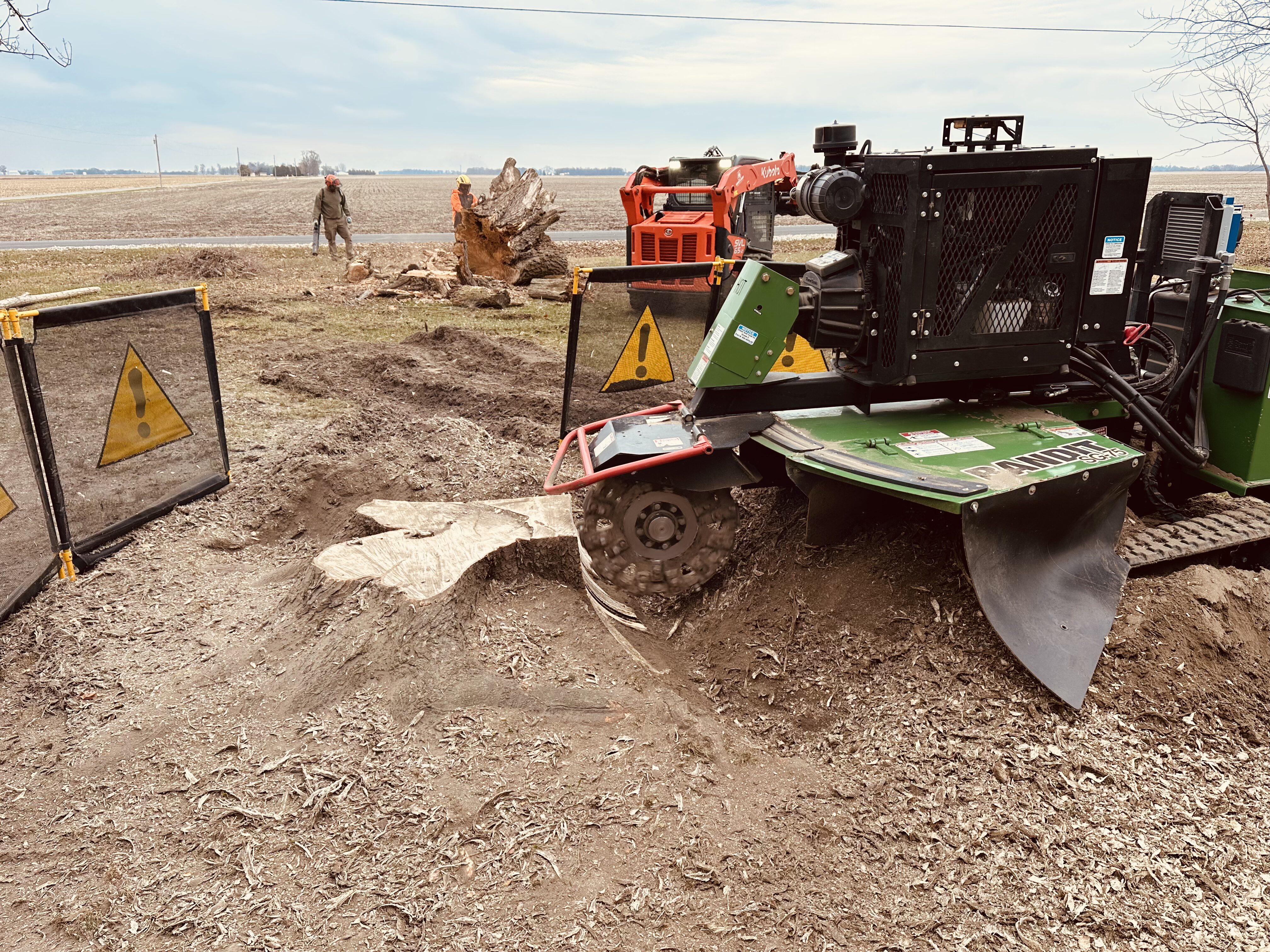 heartland stump grinding machine with caution sign surrounding it